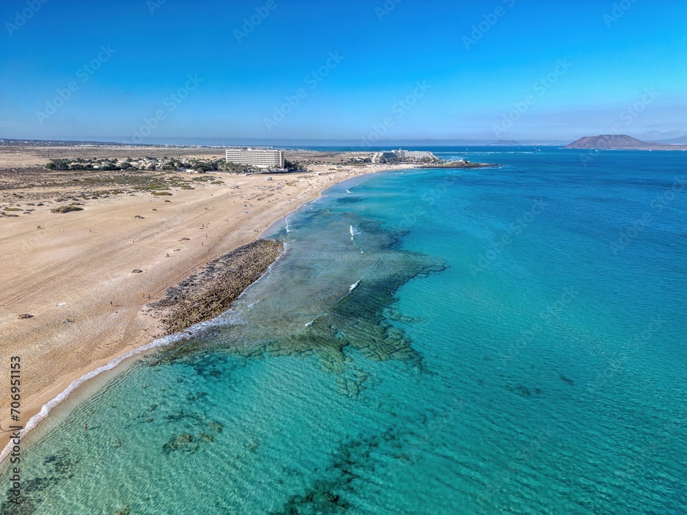 The drone aerial view of Corralejo Natural Park and grand Corralejo beach. Corralejo Natural Park is the best place to go to enjoy the desert beauty of Fuerteventura. The drone aerial view of Corralejo Natural Park and grand Corralejo beach. Corralejo Natural Park is the best place to go to enjoy the desert beauty of Fuerteventura.
