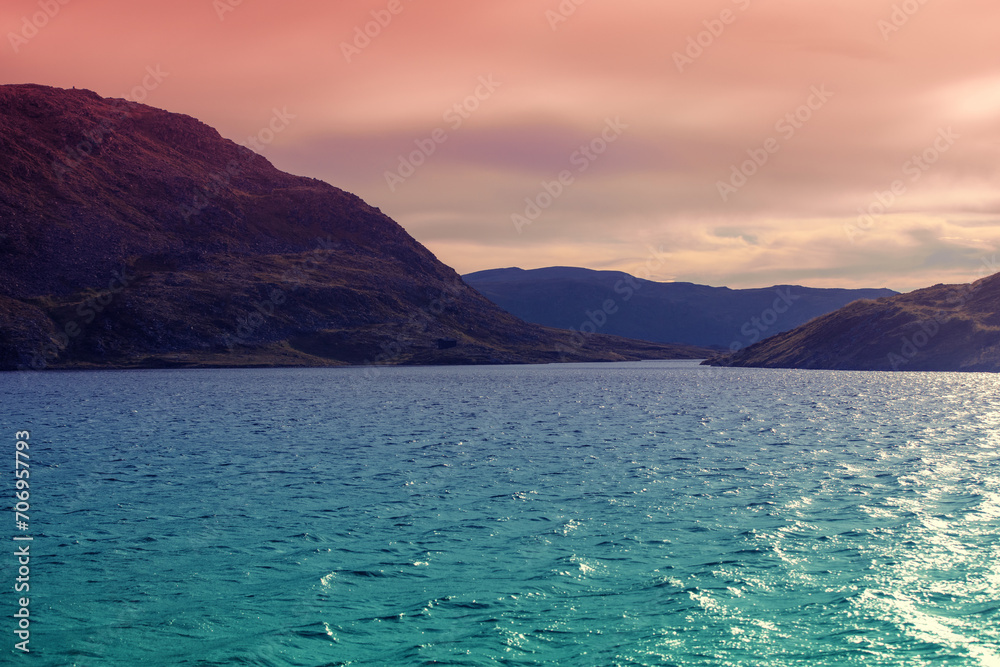 Seascape in the evening. View of the fjord. Rocky sea shore during sunset. Beautiful nature of Norway.