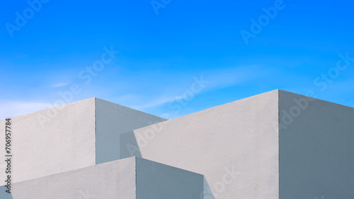 Sunlight and shadow on surface of white concrete building wall against blue sky background, Geometric exterior architecture in minimal street photography style