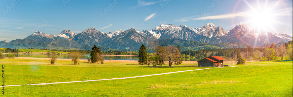 panoramic landscape and nature with lake Forggensee and alps mountain range in Bavaria, Germany