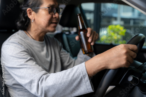 A man is drinking beer while driving