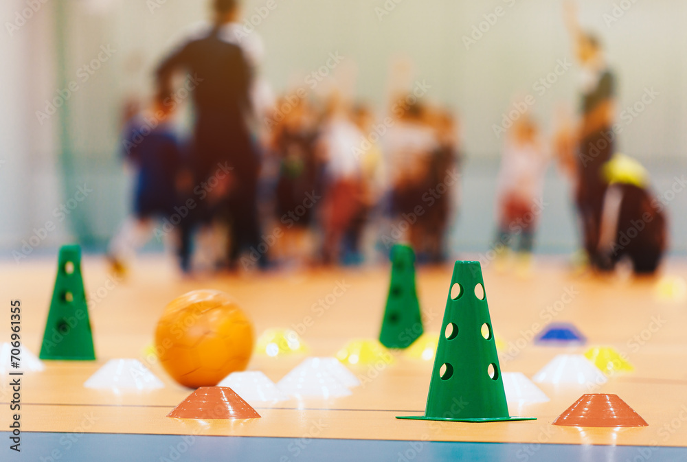 Futsal training drills. Indoor soccer equipment. Group of school children during physical education class. PE lesson training equipment tools - obrazy, fototapety, plakaty 