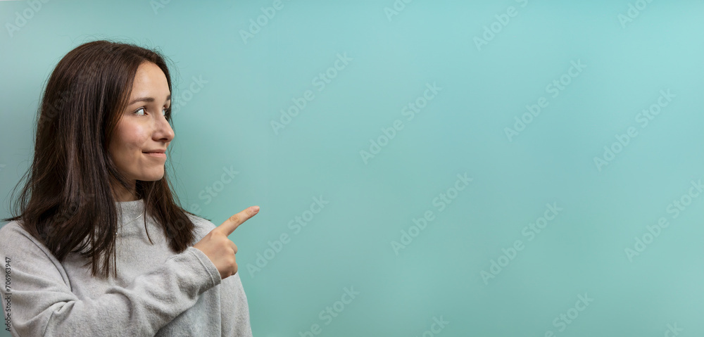 Woman pointing at blue empty background. Banner with copy space for text. Woman pointing at blue empty background. Banner with copy space for text.