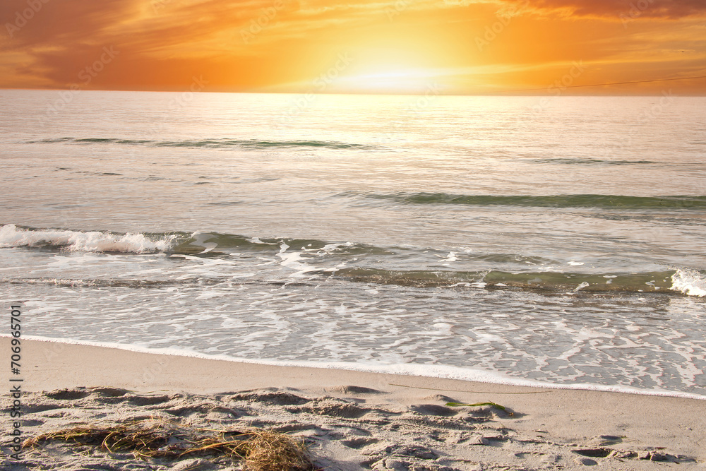 On the coast of the Baltic Sea at sunset. Waves roll onto the sandy beach. Nature