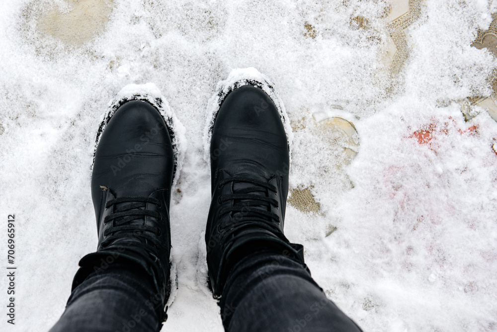 Woman in black winter leather boots on snow. Woman in black winter leather boots on snow.