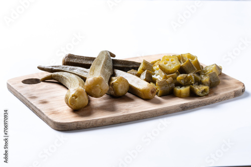 Okra slices on cutting board isolated on white background