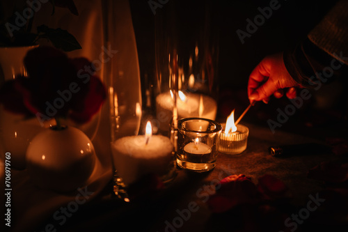 Hands light a candle. Decoration, arrangement and location preparation for surprise marriage proposal. Romantic candlelight dinner at terrace restaurant at night. Place for date or engagement.