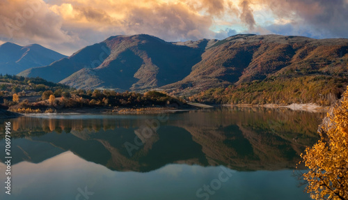 Golden Hour Serenity at a Reflective Lake Surrounded by Autumn Foliage and Rolling Hills © Pixel Harmonics