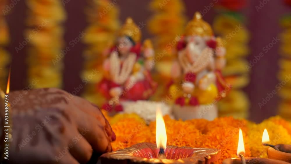 Indian woman hand placing diya in front of Hindu Gods - Diwali idol ...