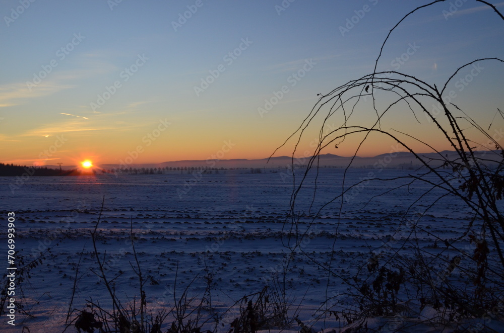 Sunset over a snowy field with trees in the foreground and mountains in the background, Beskydy , lysa hora, czech nature, 