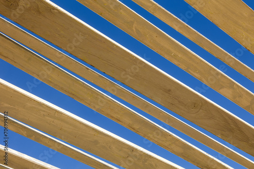 Contrasto di colori tra Travi di legno e cielo azzurro photo
