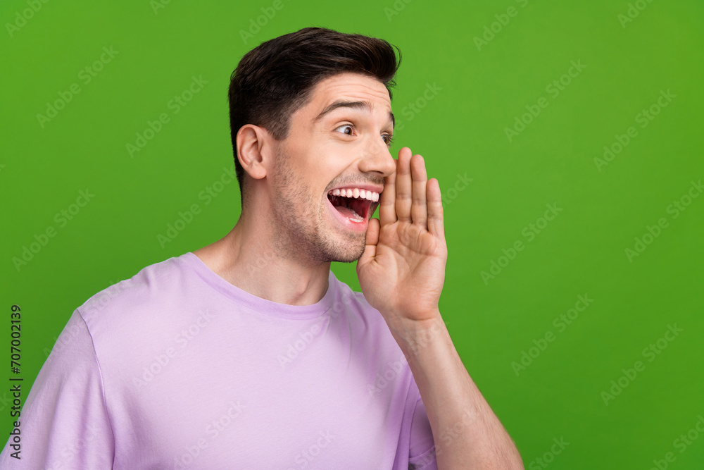 Portrait of crazy funky person wear violet t-shirt scream look at discount empty space hand on cheek isolated on green color background Portrait of crazy funky person wear violet t-shirt scream look at discount empty space hand on cheek isolated on green color background