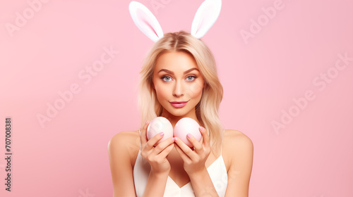 Holidays, spring and party concept. Portrait of lovely, romantic young blond woman in rabbit ears and white dress, giving you painted easter eggs as celebrating orthodox holiday, pink background