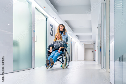 Healthcare worker pushing a wheelchair with injured woman photo