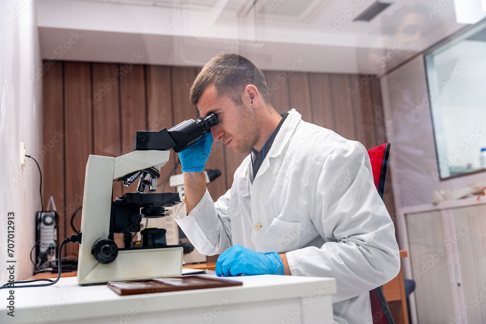 Concentrated doctor using microscope to analysis samples in a laboratory Concentrated doctor using microscope to analysis samples in a laboratory