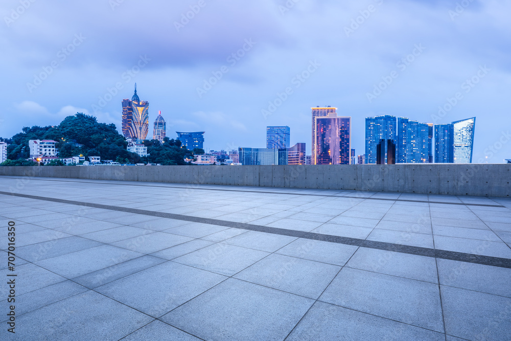 Empty square floor and city buildings landscape at night in Macau