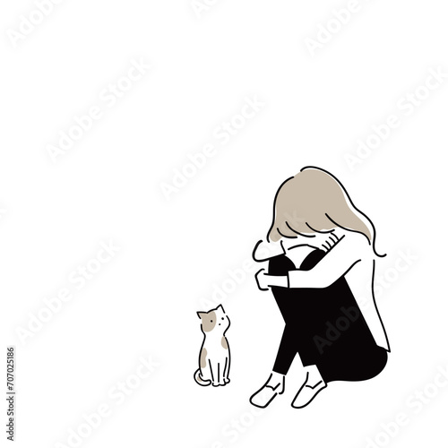 膝を抱えて落ち込む女性を心配するペットの猫