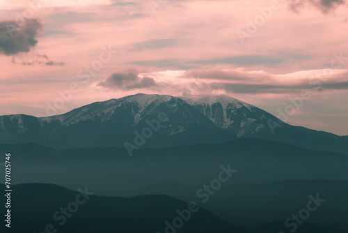 Landscape view of snowy mountains in Bulgaria with beautiful warm cloudy sky.