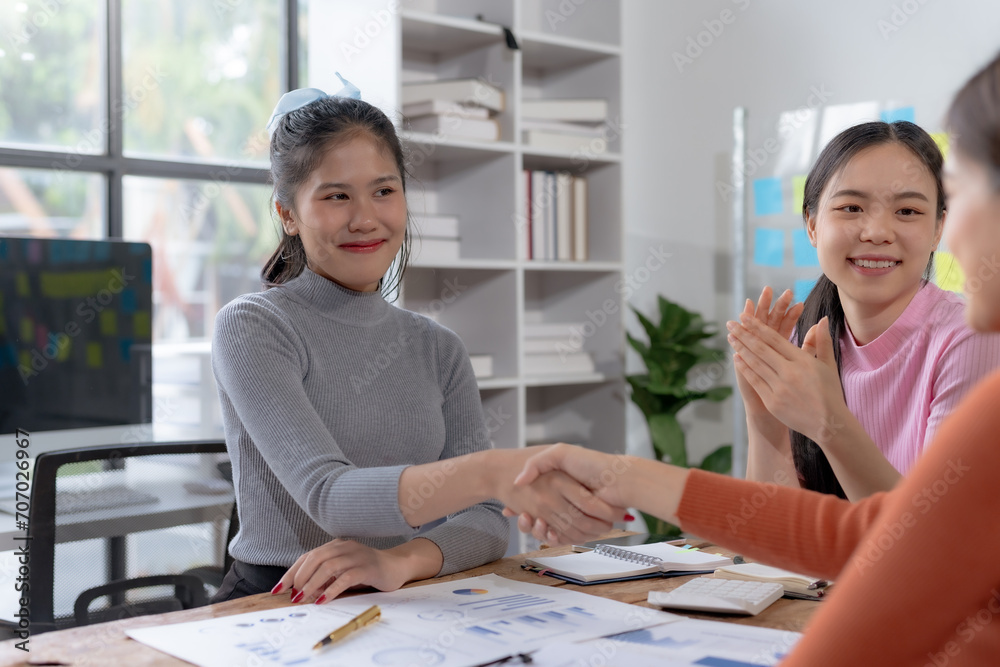 Young Asian businesswoman handshake to congratulate success.