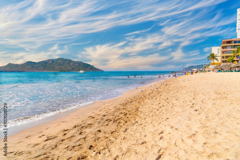 Serene Beach Scene with Mountains, Seagulls, and Resort Buildings