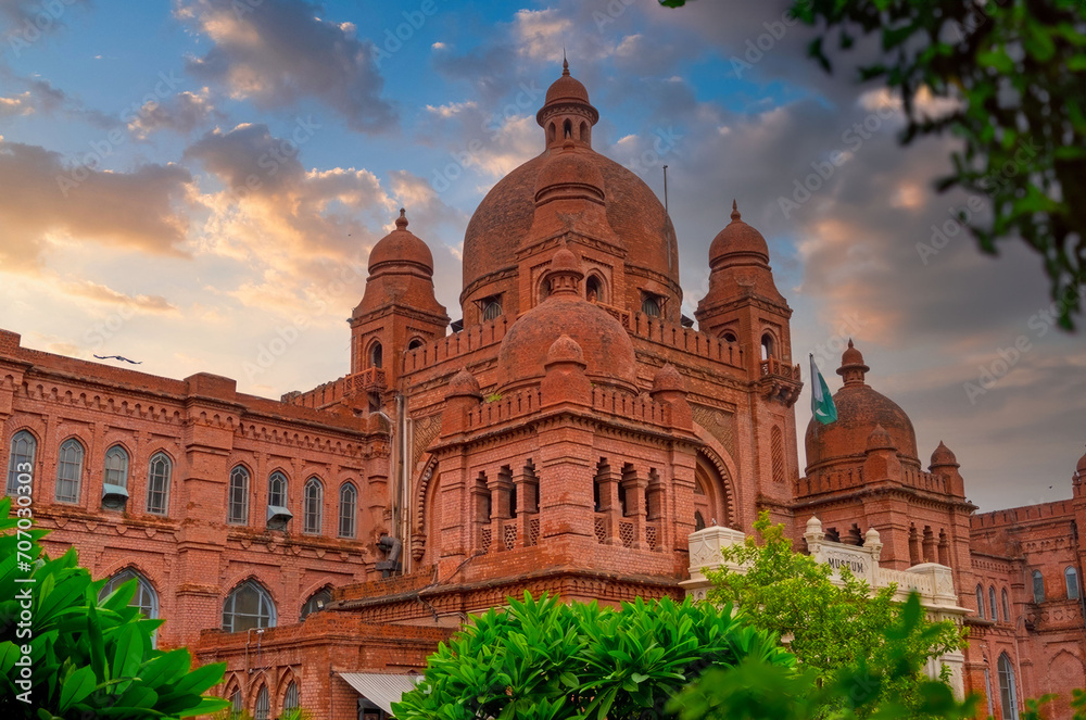 Grand Indo-Gothic Historical Museum Building at Dawn with Lush Greenery, Red Brick Domes, and Towers