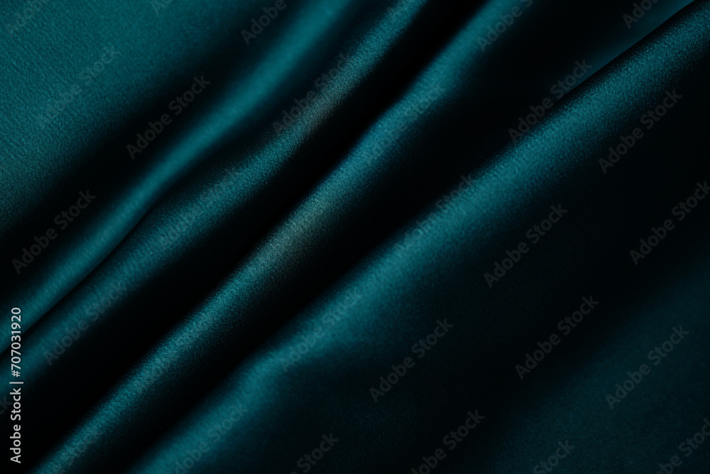 Emerald green silk or satin, draped fabric, elegant background.