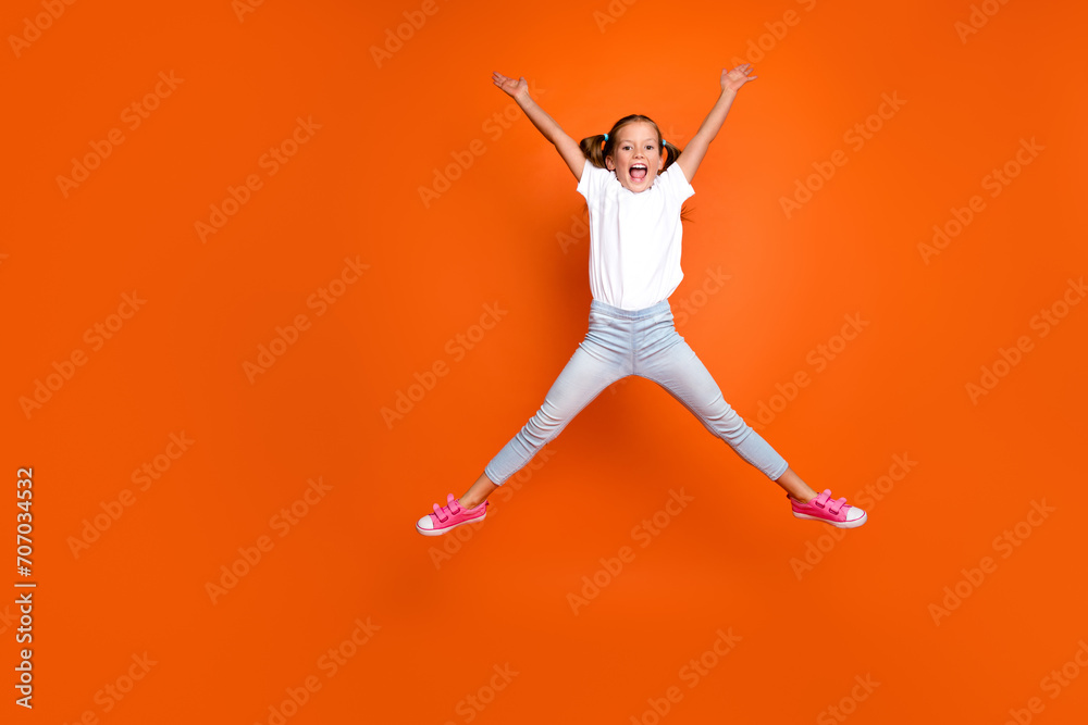 Full size portrait of active overjoyed girl jump make star figure empty space isolated on orange color background