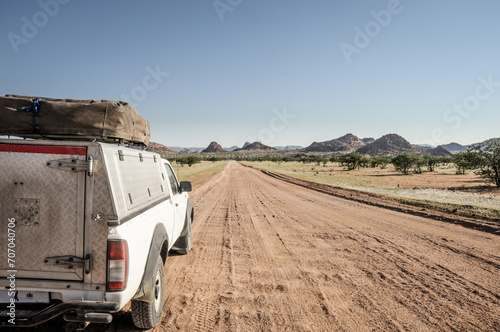 pickup truck with roof tent on a dirt road in namibia
