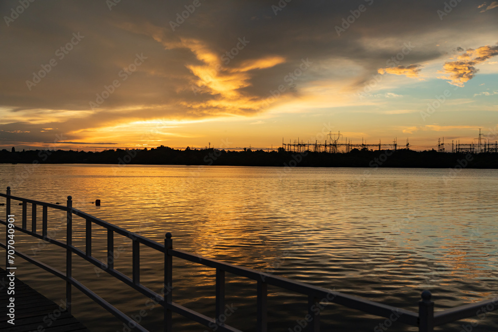sunset at coast of the lake. Nature landscape, reflection, blue sky and yellow sunlight. landscape during sunset. Bright sunset over lake