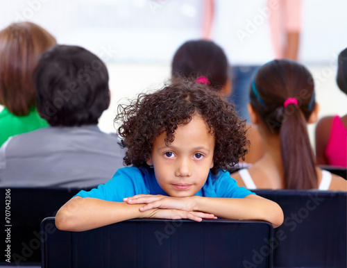 Portrait, child or boy student in classroom for knowledge, education or development for future growth. Scholarship, back to school or young male kid ready for studying, listening or learning at desk photo