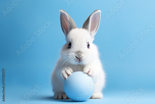 White rabbit holding a blue ball, in the style of matte background, konica big mini, light azure and gray, cute and colorful, wimmelbilder, selective focus