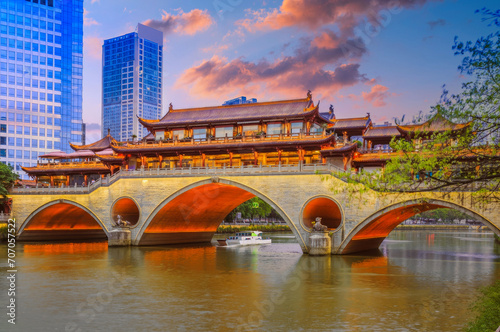 Traditional Chinese Bridge at Twilight with Illuminated Arches, Modern Skyline, and Boat in East Asia
