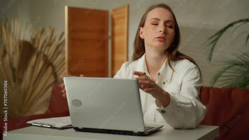 A tired young freelance woman uses a laptop, suffers from headaches, tension and migraines, and stress in the office. A woman is working with a laptop. A tired young freelance woman uses a laptop, suffers from headaches, tension and migraines, and stress in the office. A woman is working with a laptop.