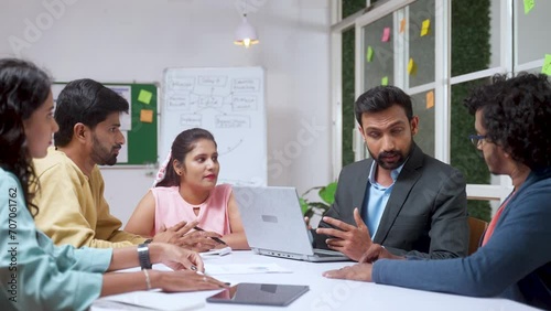 Businessman or client explaining about project at office meeting with group of team members - concept of leadership, communication and expertise