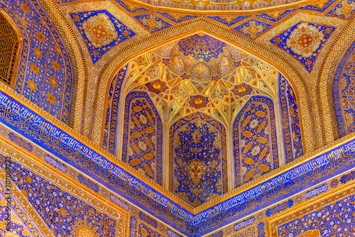 Interior of Tilya Kori Madrasah in Registan. Masterpiece of XVII century. Golden and blue. Arabic text of Qran (sacred book of muslims) used as part of ornament. April 24, 2023. Samarkand, Uzbekistan