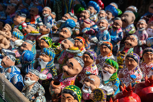 Ceramic figures of Uzbek men and women in traditional clothes. Souvenirs at showcase, gift market in Bukhara (Buxoro). Uzbekistan