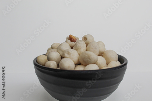 Kacang Atom, snack from Indonesia, made from peanut covered by flour dough then fried. On black bowl, isolated on white background photo