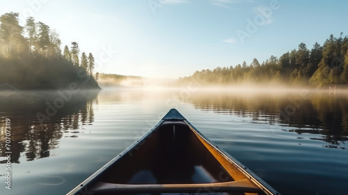 Bow of a canoe in the morning on a misty lake in Ontario, Canada. © NooPaew