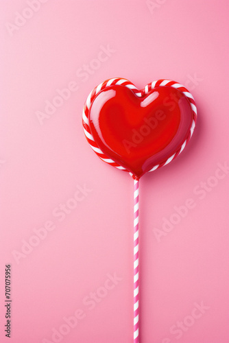 Heart shaped lollipop candy on pink background. Valentines day concept.