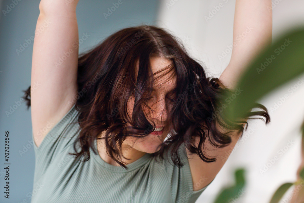 Fototapeta premium Cheerful women jumping or doing sports indoor, looking back at camera while moving with broad smile