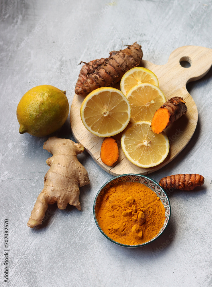 Lemon, turmeric root and ginger. Anti viral homemade medicine ingredients on light gray background with copy space. 