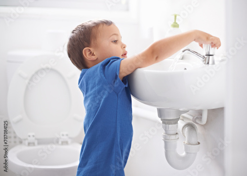Child, boy and washing hands in bathroom, hygiene and prevention of germs or bacteria at home. Male person, kid and learning at basin or cleaning and sanitary care, water and disinfection for safety