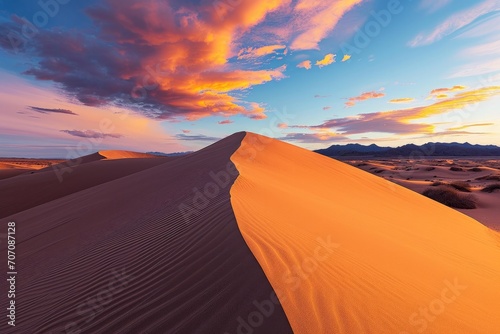 A majestic sand dune rises against a serene blue sky, its rippling surface beckoning to the horizon as the singing sand dances in the desert winds