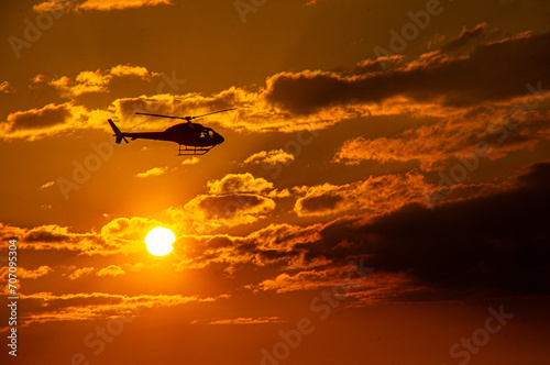 Helicopter flying over the sunset