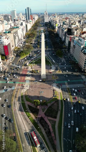 Vertical Aerial drone view of Buenos Aires obelisk on avenida de Julio in Buenos Aires, Argentina. Shows buildings and skyscrapers with car traffic in the Street below.
