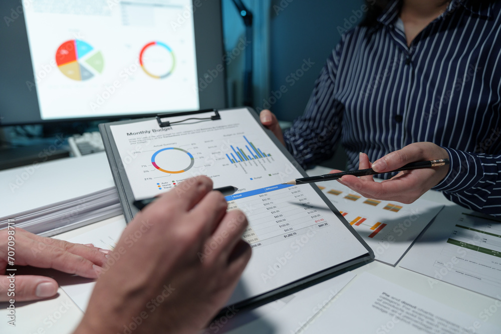 Group of business people meeting, discussion, brainstorming, pointing at graphs and charts to analyze market data, calculating balance sheets, accounts, net profits to plan company sales strategies. Group of business people meeting, discussion, brainstorming, pointing at graphs and charts to analyze market data, calculating balance sheets, accounts, net profits to plan company sales strategies.