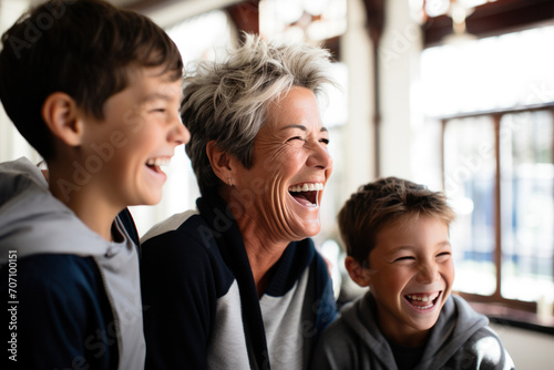 A joyous portrait captures an affectionate grandmother bonding with excited grandchildren indoors.