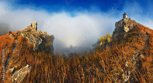 Church on the rock. Autumn landscape with fog. Nature of Ukraine
