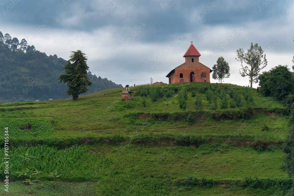 Kleine Kirche auf einem Hügel unter wolkigem Himmel
