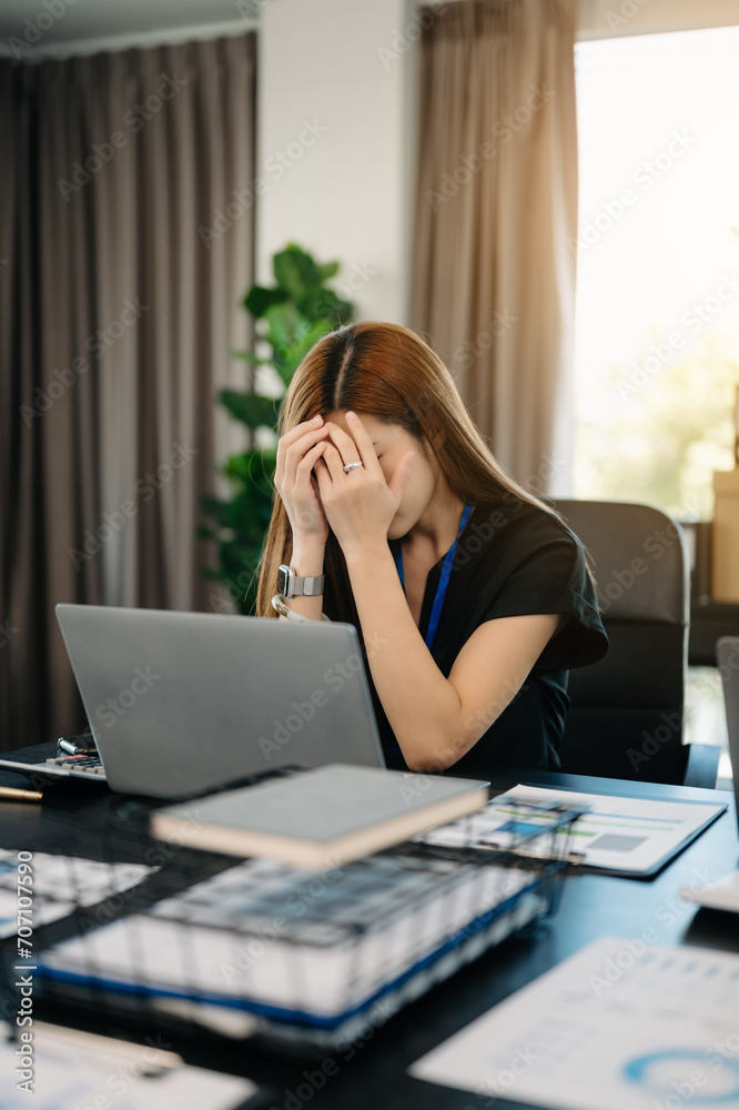 Asian business woman is stressed, bored, and overthinking from working on a tablet . Asian business woman is stressed, bored, and overthinking from working on a tablet .